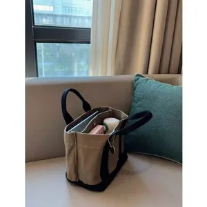 Detail shot of the multi-compartment canvas tote bag showcasing interior storage and sturdy handles.