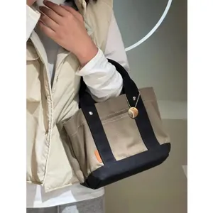 Canvas tote bag detail view, multi-compartment daily handbag for women, casual style.