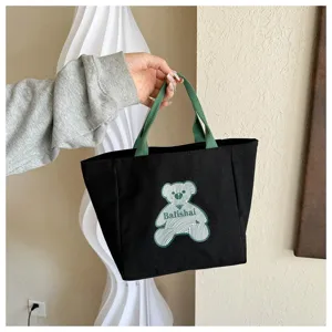 Black canvas tote bag, casual shoulder bag with green handle and cute bear pattern for women.