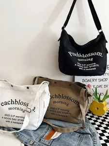 Casual canvas shoulder bag for women, large capacity tote bag with letter print for daily commute.