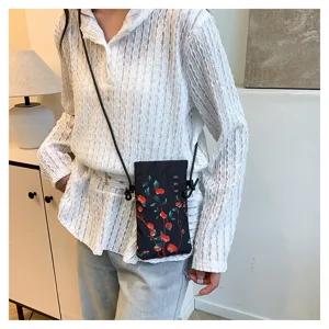 Chinese style retro crossbody phone bag for women, chic black canvas small shoulder bag detail.