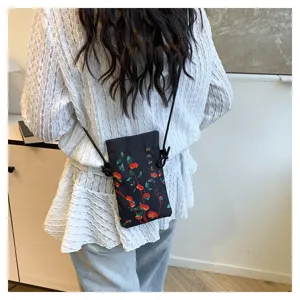 Detailed view of a vintage Chinese style fabric crossbody phone bag with persimmon floral print.