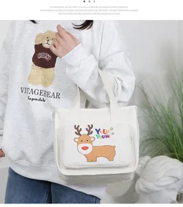 Detailed shot of thick canvas insulated lunch bag with cute deer print and carry handles.