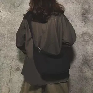 Casual black canvas crossbody bag detail shot, minimalist design, perfect for daily wear.