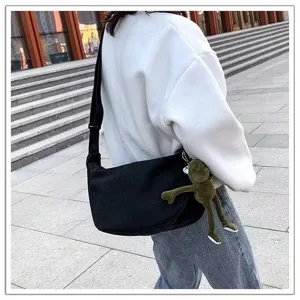 Black canvas crossbody bag with frog pendant, casual large shoulder bag for daily use.