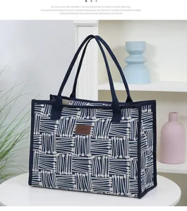 Canvas tote bag detail view showing blue geometric pattern and dual shoulder straps.