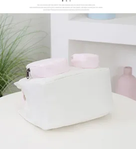 Mini white handbag detail view with pink top pockets in minimalist clean studio scene.
