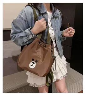 Cute brown backpack detail showing cute bear face patch, green straps, and practical drawstring.
