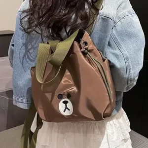 Brown nylon backpack with cute bear embroidery, ideal for casual daily use and travel.