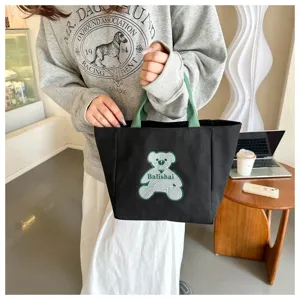 Casual black canvas tote bag with green handles and cute bear embroidery for daily use.