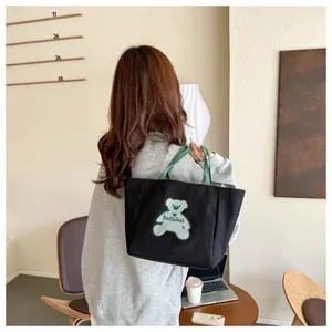 Black canvas shoulder bag for women, trendy casual tote bag with cute bear pattern, stylish daily handbag.