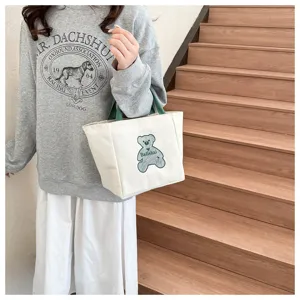 Cute small canvas tote bag for women, casual daily handbag with green handles and bear print.