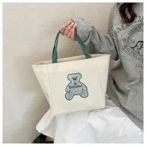 Casual canvas tote bag with green handles and cute bear print, stylish handbag for daily use.