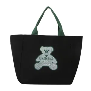 Black canvas tote bag for women with green handles and bear graphic, stylish casual shoulder bag.
