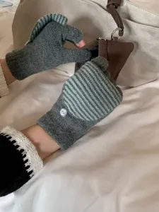Primo piano dettagliato di guanti in maglia a righe senza dita con risvolto in uso.