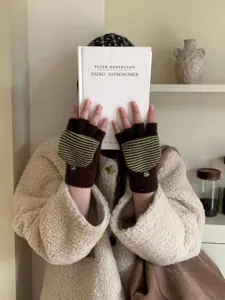 Dettaglio in primo piano di guanti lavorati a maglia a righe senza dita con bottoni invernali.