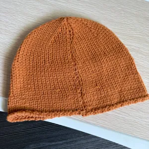Braune Strickmütze Detail, gemütliche Winter Beanie Mütze, weiches warmes Strickaccessoire.