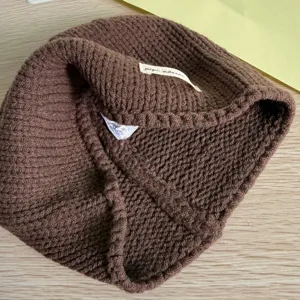Detailansicht einer gemütlichen braunen Strickmütze im Winter mit innerem Etikett.