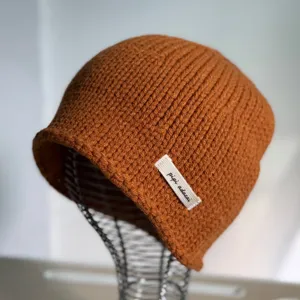 Detailansicht braune Strickmütze, warme Winter Beanie, Nahaufnahme der Rippenstrickoptik.