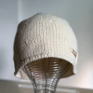 Cremeweiße Strickmütze Detail, lässige Winter Rippstrick Melonenmütze Nahaufnahme.