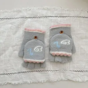 Close-up detail of grey and pink plush half-finger convertible gloves with cute embroidery.