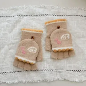Detail of plush convertible half finger winter gloves with cute knit musical note design.