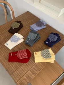 Dettaglio guanti mezza dita in maglia, design con risvolto a righe caldo per inverno.