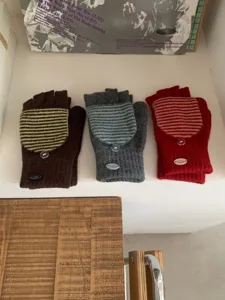 Dettaglio guanti senza dita in maglia, comoda copertura a righe con bottone caldo.