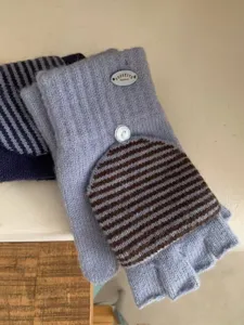 Primo piano dettagliato dei guanti invernali in maglia senza dita con righe marroni.