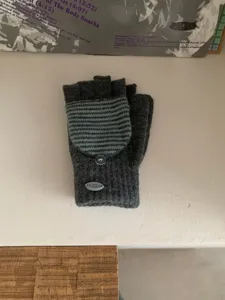 Dettaglio guanti lavorati a maglia senza dita, copridito a righe grigie, inverno caldo.