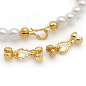 Close-up of gold plated OT clasps and flower connectors for DIY jewelry crafting.