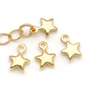 Vista detallada de dijes de estrella dorados, pequeños colgantes de metal para joyería.