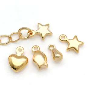 Vista detallada de dijes 3d de cobre chapado en oro con corazón y estrella para joyería DIY.