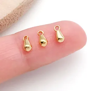 Primer plano de dijes colgantes de gota chapados en oro 18k para accesorios de joyería diy.