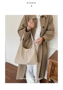 Beige suède schoudertas voor dames, grote shopper tas met mooie strik en trekkoord.