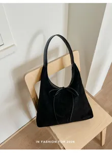 Detailfoto van zwarte suède hobo tas met strik op houten stoel voor mooie weergave