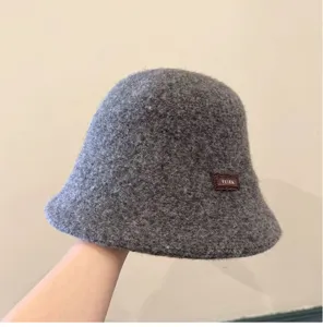 Chapeau seau d'hiver en laine grise, chapeau bassin chaud détail texture douce.