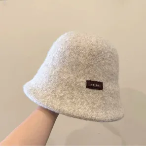 Vue détaillée d'un chapeau seau en laine épaisse et chaude, couleur avoine, confortable.