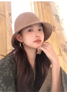 Detail shot of the elegant wool bucket hat worn in a classic outdoor scene, autumn style.