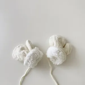 Détail de moufles d'hiver douillettes pour bébé avec doublure en peluche et cordon de cou.