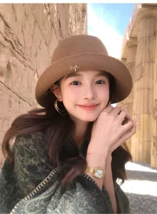 Elegant wool bucket hat detail, wide brim design with chic brooch, vintage autumn style.