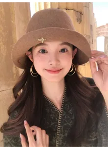 Detail shot of elegant brown pure wool bucket hat worn by model, cozy autumn winter headwear.