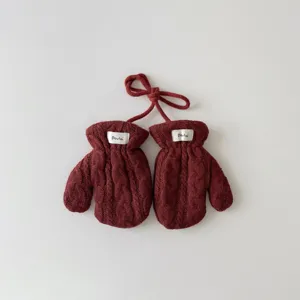 Détail de gants d'hiver pour enfants en tricot avec cou, moufles rouges épaisses dehors.