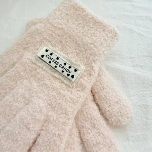 Close-up of kids fuzzy knit gloves with cute label detail, soft warm texture for winter.