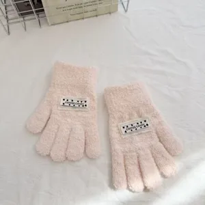 Cute pink fuzzy knit gloves detail showing soft texture and sweet heart label design.