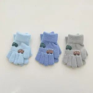 Gros-plan sur les détails des gants tricotés pour enfants avec joli motif de voiture d'hiver.