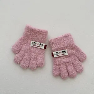 Vue de détail de gants pour enfants tricotés roses à cinq doigts avec joli badge chat.