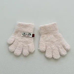 Gros plan de mignons gants tricotés à cinq doigts pour enfants roses avec étiquette de chat.