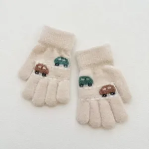 Gros plan détaillé de gants tricotés pour enfants avec des motifs de voitures mignonnes.