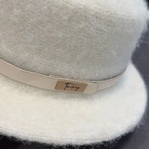 Nahaufnahme Detail des flauschigen flachen Wollhutes, mit einem schicken Lederband und Metall.